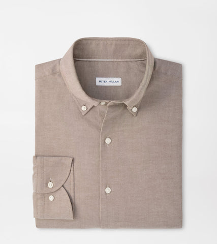 A folded Peter Millar long-sleeve button-down shirt in a light taupe-beige color, displayed on a clean white background.