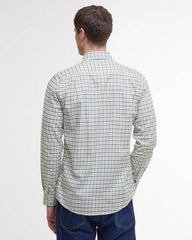 A man viewed from the back wearing a long-sleeve button-up shirt with a fine black and white grid pattern, paired with blue jeans, against a plain white background.