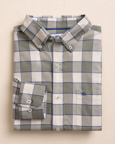 A folded long-sleeve button-down shirt with a gray, white, and blue windowpane plaid pattern, displayed on a neutral beige background.