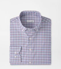A folded Peter Millar long-sleeve button-down shirt with a fine red and blue check pattern on a white base, shown on a solid white background.